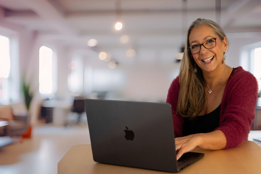 Elke Egi vor Notebook am Schreibtisch Online-Suche Graz